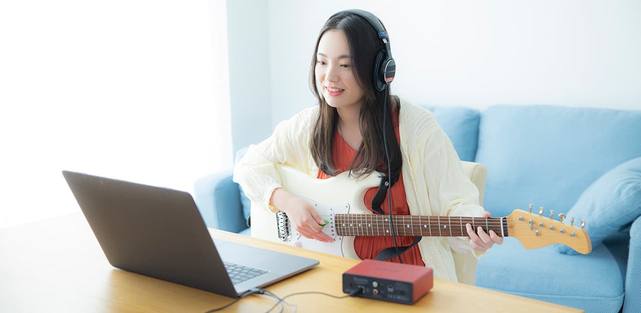 自宅でオンライン・ギターレッスンを受講する女性|エレキギターコース